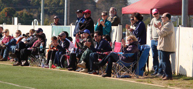 A group of people watching a soccer game.