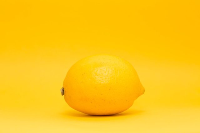 A lemon on a yellow background.