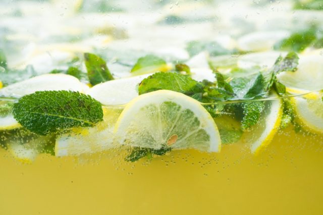 A pitcher of lemonade with lemon slices and mint leaves.