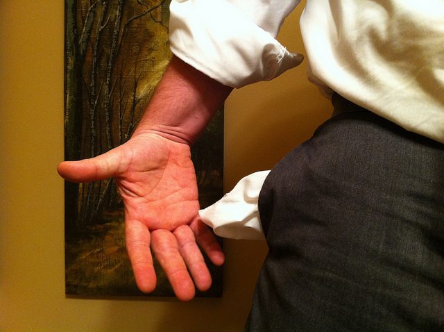 A white shirt on a man's hand.