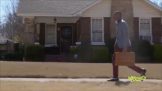 A man carrying a briefcase in front of a house.