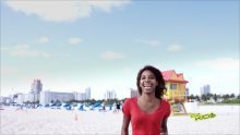 a woman in a red top is at the beach and smiling
