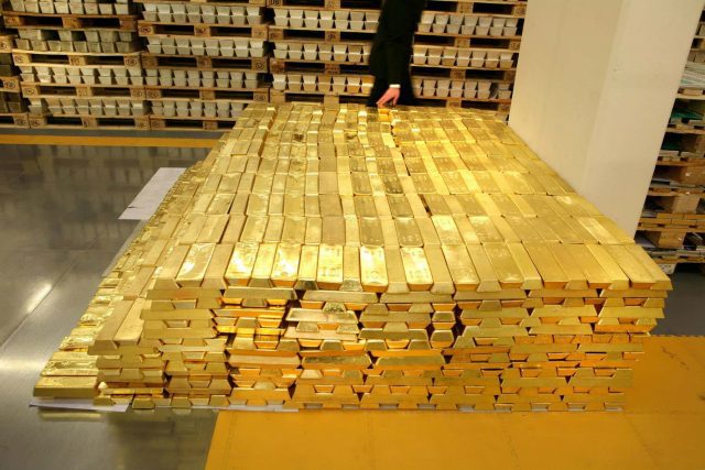 A pile of gold bars in a warehouse.