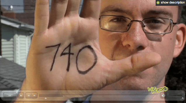 A man holding up a hand with the number 440 written on it.