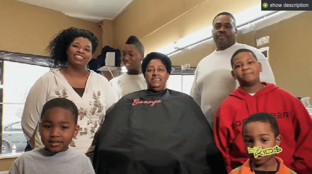 A family is posing for a picture in a barber shop.