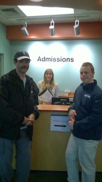 Three people standing in front of the admissions office.