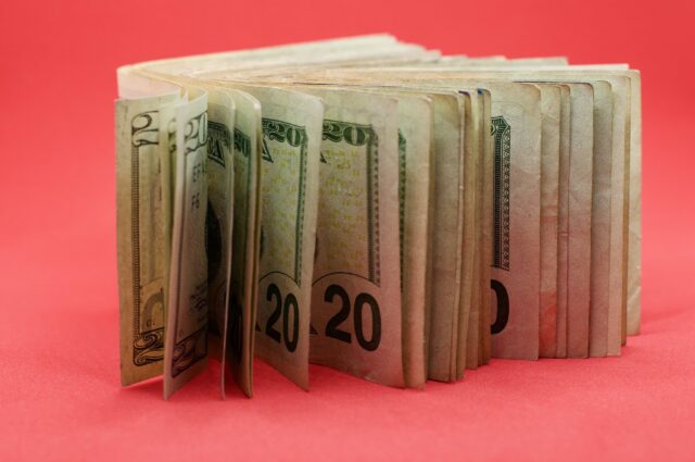 A stack of japanese dollar bills on a red background.