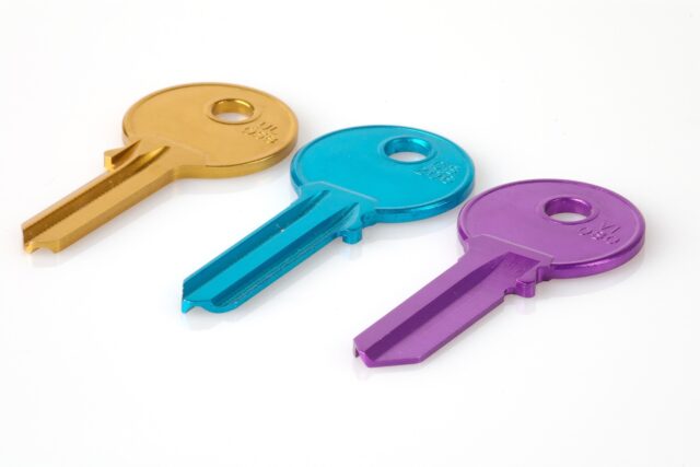 Three colorful keys lying on a white surface.