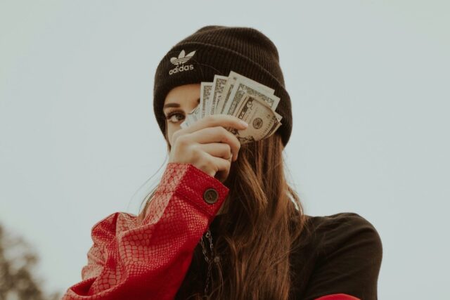 A girl with money on her head.