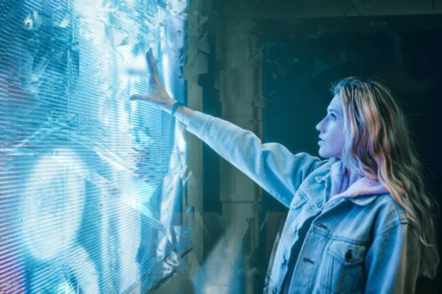 A girl touching a wall screen with some lights
