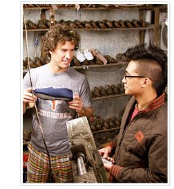 Two men standing next to each other in a shoe shop.