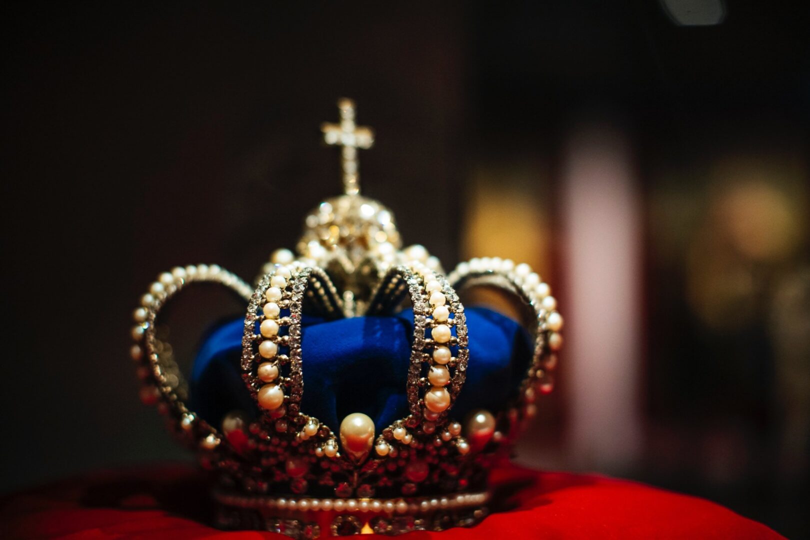 A blue and gold crown sits on top of a red cloth.