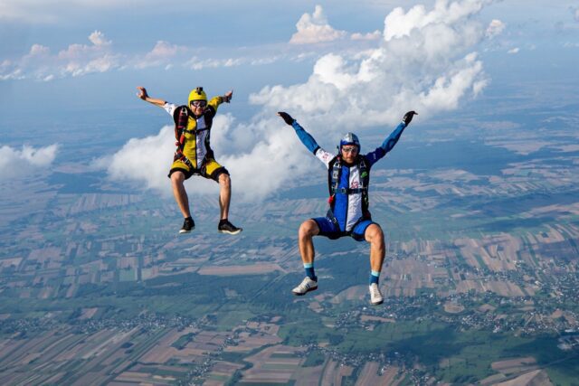 Two men skydiving in a blue and yellow helmet