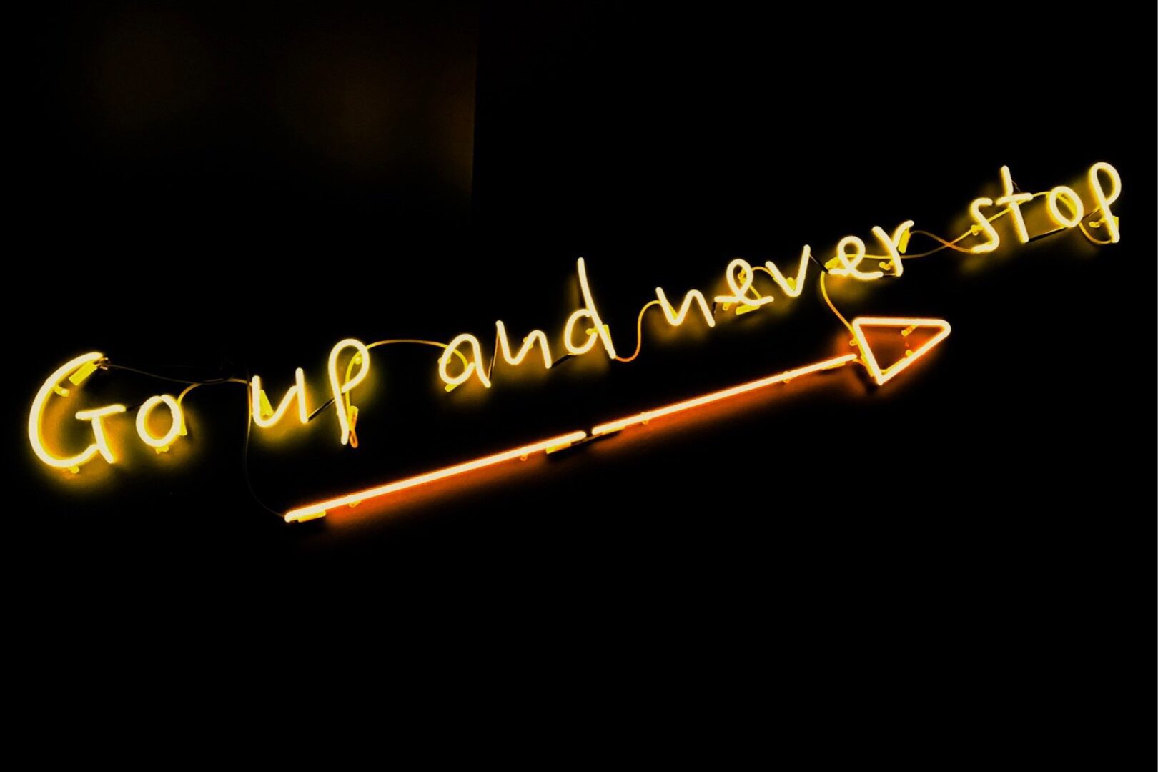 A neon sign that says go up and never stop.