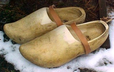 A pair of wooden clogs sitting in the snow.